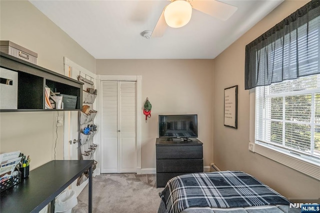carpeted bedroom featuring a closet, baseboards, and ceiling fan