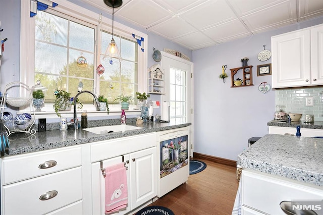 kitchen featuring white cabinets, backsplash, baseboards, and dark wood-style floors