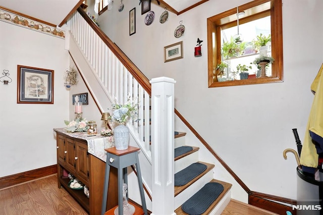 stairway featuring baseboards and wood finished floors