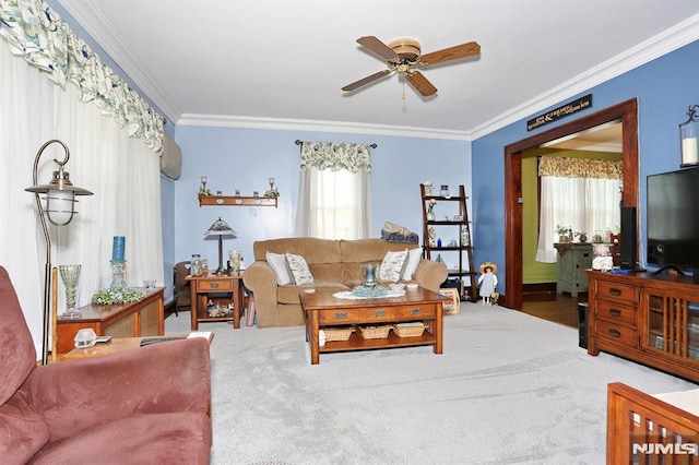 carpeted living room with ornamental molding and a ceiling fan