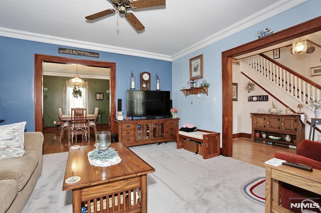 living room with baseboards, a ceiling fan, stairs, and ornamental molding