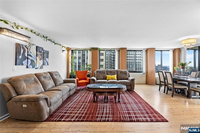 living room with wood finished floors and a notable chandelier