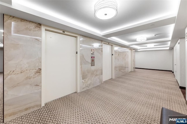 corridor featuring elevator and carpet