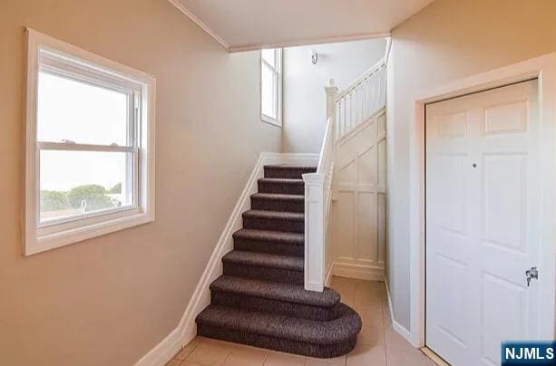 stairs with tile patterned flooring and baseboards