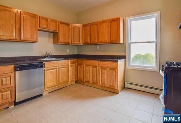 kitchen featuring brown cabinets, dark countertops, baseboard heating, a sink, and stainless steel dishwasher