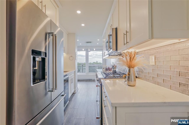 2077 Center Ave Unit 11C, Fort Lee, NJ 07024 - kitchen with premium appliances, dark wood finished floors, backsplash, white cabinets, and recessed lighting