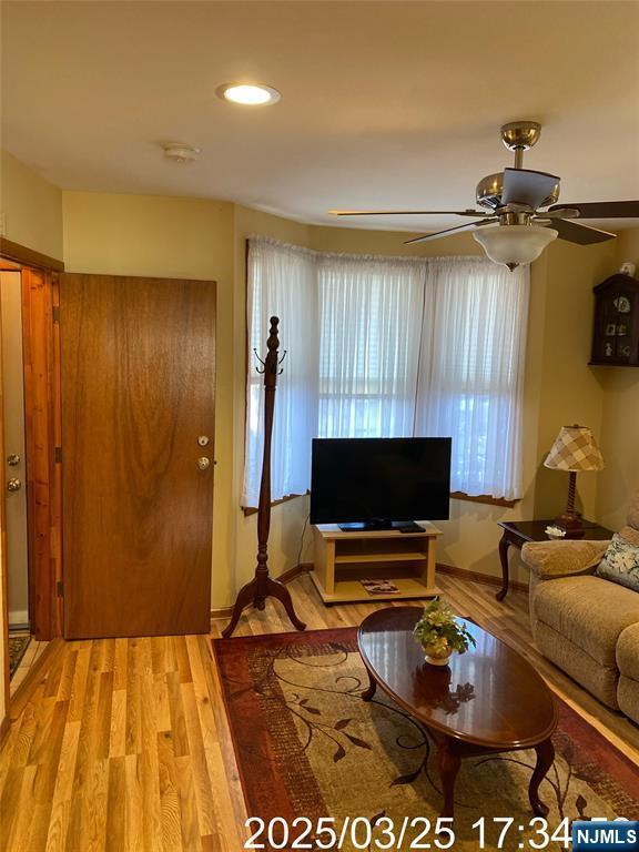living area with a ceiling fan, light wood finished floors, and recessed lighting