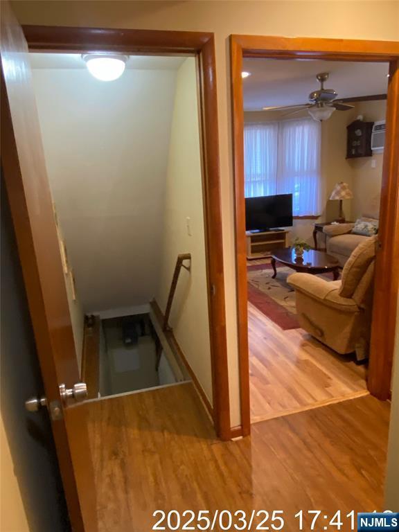 staircase featuring ceiling fan and wood finished floors