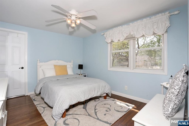 bedroom featuring baseboards, wood finished floors, and a ceiling fan