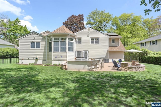 back of house with an outdoor fire pit, solar panels, a patio, and roof with shingles