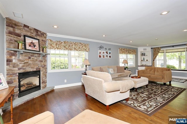 living room featuring crown molding, baseboards, wood finished floors, a stone fireplace, and recessed lighting