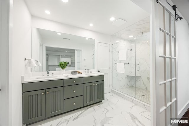 bathroom with marble finish floor, a sink, a marble finish shower, and recessed lighting