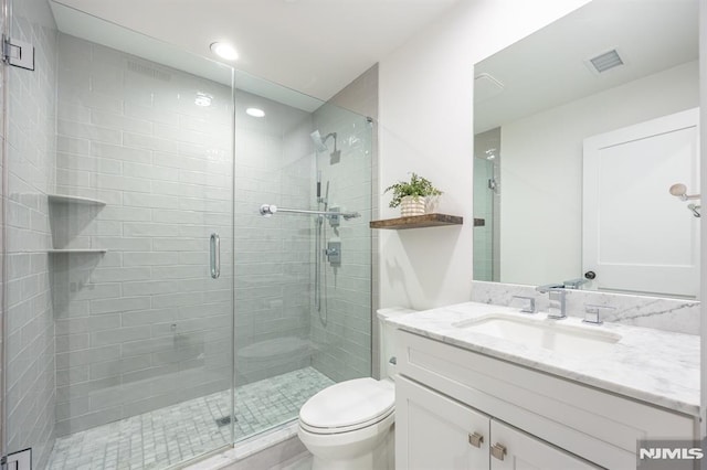 bathroom featuring a shower stall, visible vents, toilet, and vanity