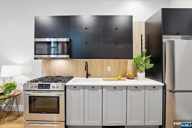 kitchen with light countertops, appliances with stainless steel finishes, and a sink