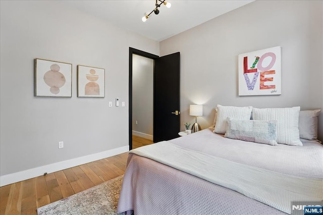 bedroom with wood-type flooring and baseboards