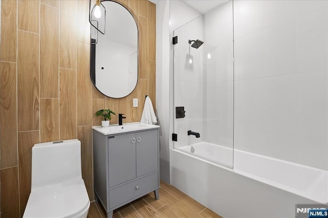full bathroom with toilet, wood finished floors, vanity, and shower / tub combination