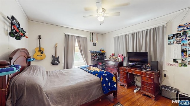 bedroom with ornamental molding, wood finished floors, and a ceiling fan