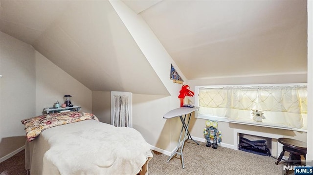carpeted bedroom featuring baseboards and lofted ceiling