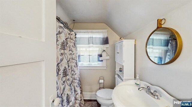 full bath featuring lofted ceiling, a sink, toilet, and a shower with curtain