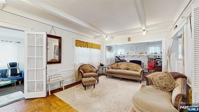 living area featuring french doors, beam ceiling, a fireplace, and a wealth of natural light