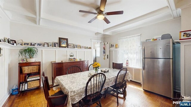 dining room with wainscoting, a decorative wall, and ceiling fan