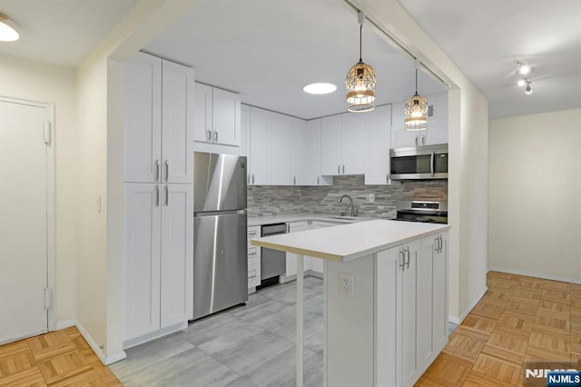 kitchen featuring a kitchen breakfast bar, tasteful backsplash, appliances with stainless steel finishes, light countertops, and a sink