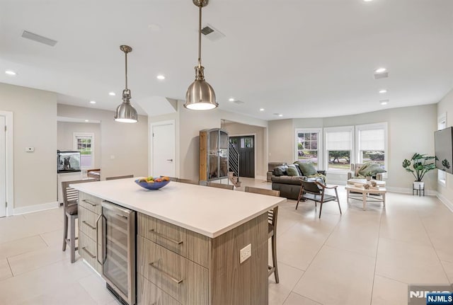334 Durie Ave, Closter, NJ 07624 - kitchen featuring wine cooler, a breakfast bar area, a kitchen island, light brown cabinets, and recessed lighting