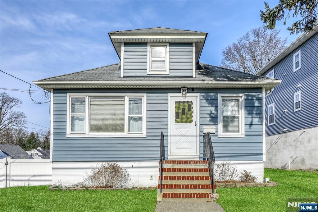 bungalow-style house featuring a front lawn, roof with shingles, and entry steps