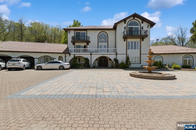 view of front of home with stucco siding and a balcony