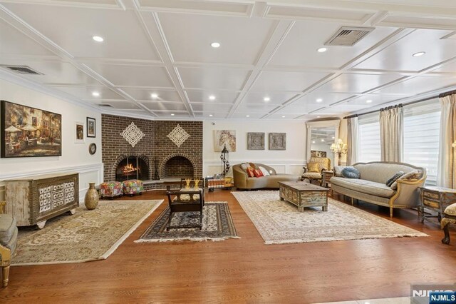 living area with a fireplace, recessed lighting, wood finished floors, visible vents, and coffered ceiling