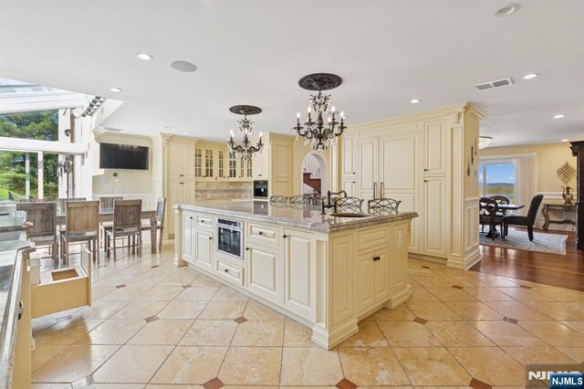 kitchen with visible vents, light tile patterned floors, a chandelier, and cream cabinets
