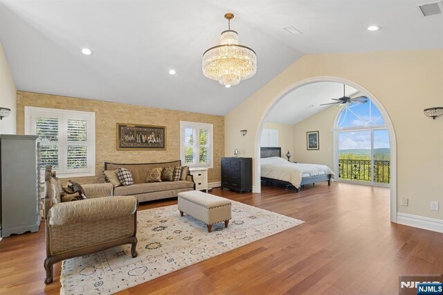 bedroom featuring visible vents, wood finished floors, lofted ceiling, access to exterior, and a chandelier
