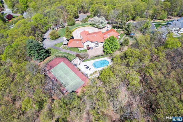 birds eye view of property featuring a view of trees