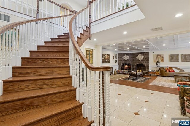staircase with visible vents, recessed lighting, tile patterned floors, and a fireplace