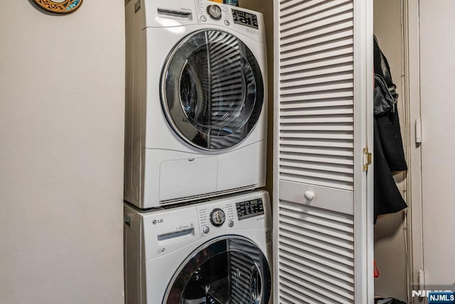 laundry room featuring stacked washer / drying machine and laundry area
