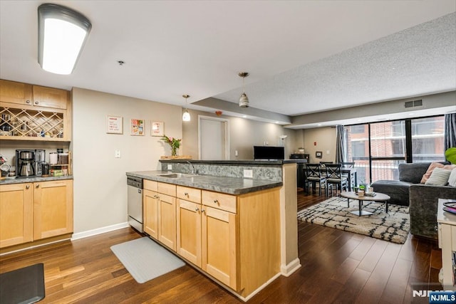 kitchen with a peninsula, stainless steel dishwasher, dark wood finished floors, open floor plan, and light brown cabinets