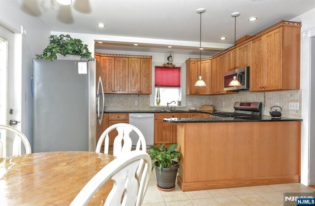 279 Boonton Ave, Butler Borough, NJ 07405 - kitchen with stainless steel appliances, a sink, light tile patterned flooring, decorative backsplash, and a peninsula