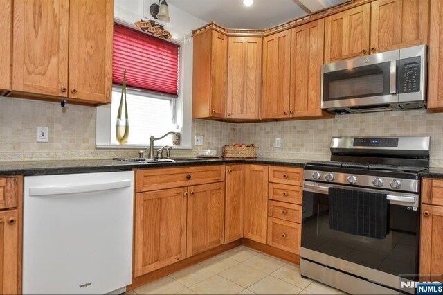 279 Boonton Ave, Butler Borough, NJ 07405 - kitchen featuring decorative backsplash, appliances with stainless steel finishes, a sink, and light tile patterned floors