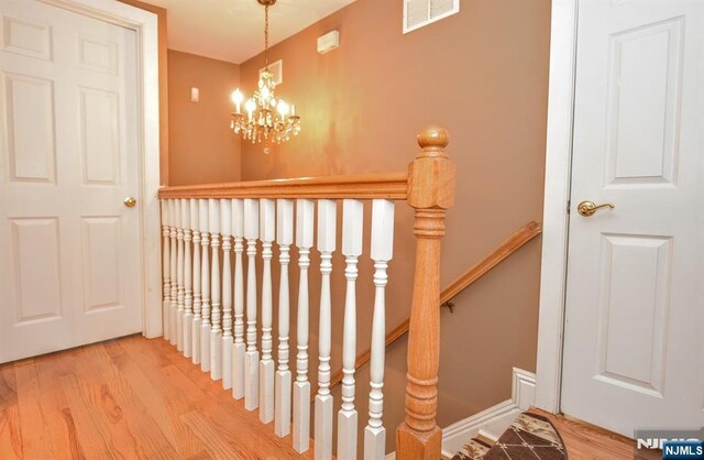 279 Boonton Ave, Butler Borough, NJ 07405 - stairs with a chandelier, wood finished floors, and visible vents