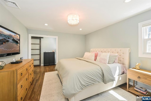 bedroom with visible vents, dark wood-style floors, recessed lighting, and a notable chandelier