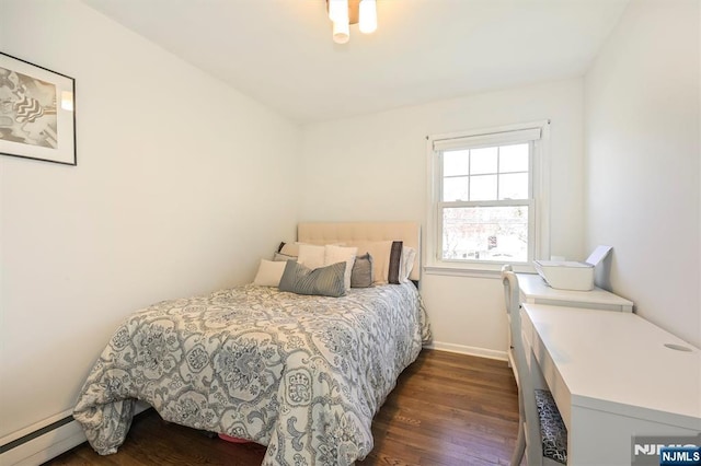 bedroom featuring a baseboard radiator, baseboards, and dark wood-style flooring