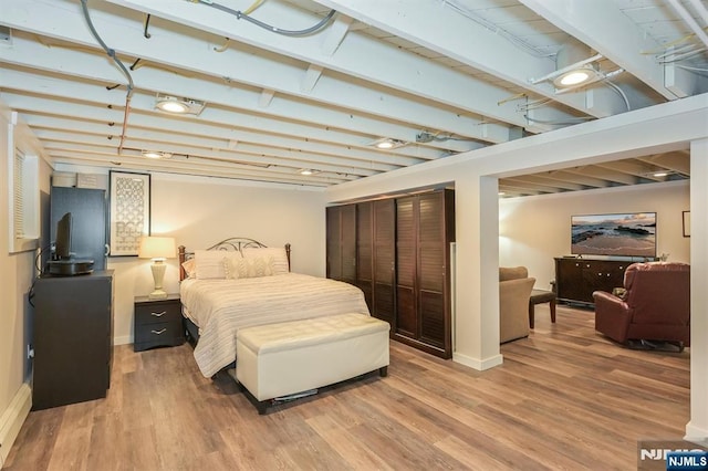 bedroom featuring light wood-style floors, a closet, and baseboards