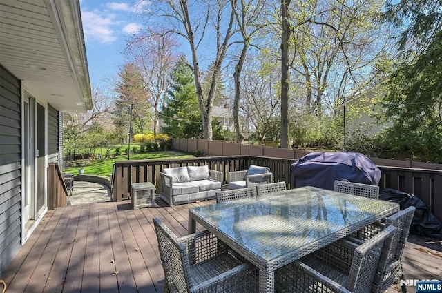 deck with grilling area, outdoor dining area, and fence