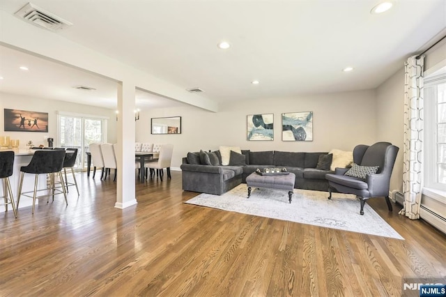 living room with recessed lighting, wood finished floors, and visible vents