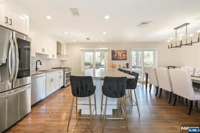 kitchen featuring a wealth of natural light, stainless steel appliances, visible vents, and a kitchen island