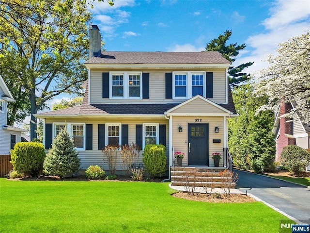 322 Fairfield Ave, Ridgewood, NJ 07450 - view of front facade featuring a chimney, a shingled roof, and a front lawn