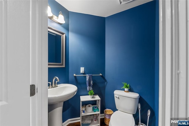 bathroom with toilet and baseboards