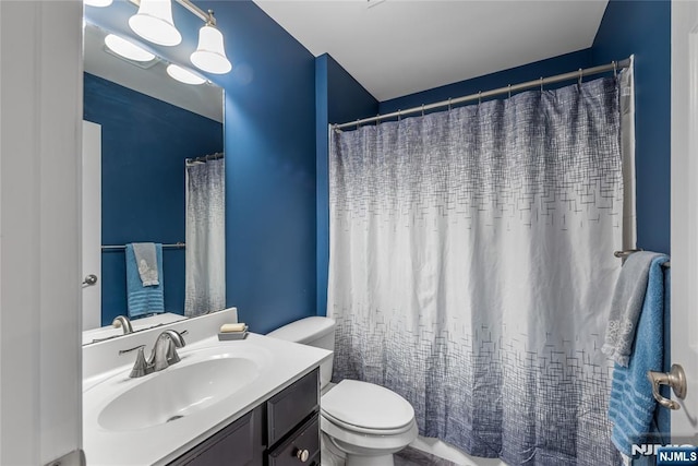 full bathroom featuring toilet, a shower with shower curtain, and vanity