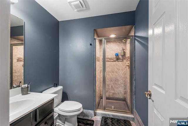 bathroom with tile patterned flooring, toilet, a stall shower, and vanity