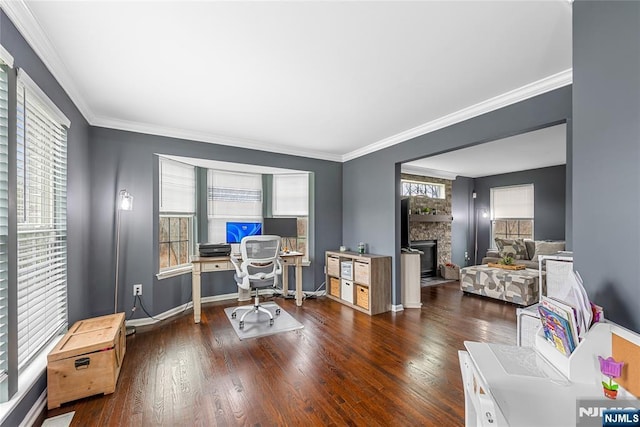 home office featuring baseboards, a stone fireplace, ornamental molding, and wood finished floors